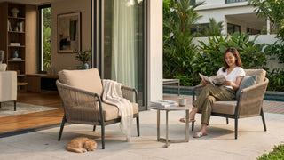 Woman reading on an outdoor garden chair beside a small table in a Singapore patio setting