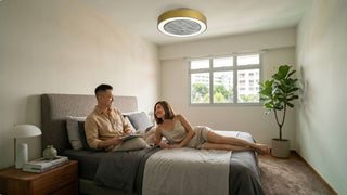 Gold bladeless ceiling fan with light in a modern Singapore bedroom with neutral bedding and soft daylight
