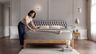 Grey fabric bed frame with wooden base, soft bedding and neutral bedroom styling for a calm Singapore home
