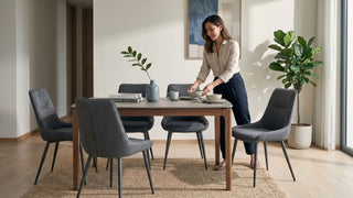 Grey fabric dining chairs around a wooden dining table in a bright Singapore dining room with natural light