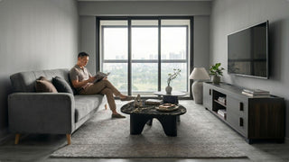 Man reading on a grey sofa in a modern container-style Singapore living room
