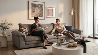 Couple relaxing on a grey sofa in a warm soft modern Singapore condo living room