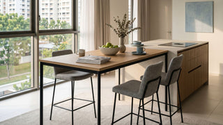 High bar table with grey stools beside a kitchen island in a bright Singapore apartment.