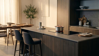 Induction-compatible pot on a modern kitchen island with built-in induction hob in a warm Singapore home.
