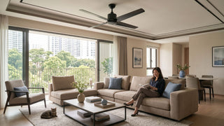 Industrial black ceiling fan in a spacious Singapore living room with beige sofa, balcony view, and modern dining area.