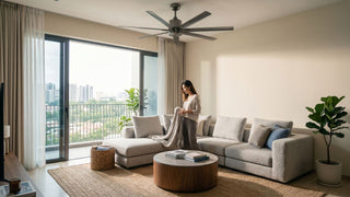 Industrial-style ceiling fan above a neutral condo living room in Singapore with a sectional sofa, balcony view, and warm daylight.