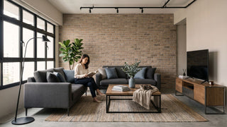 Industrial condo living room with grey sofa, brick feature wall, black track lighting, wooden coffee table and TV console