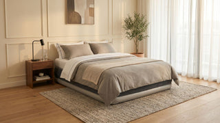 Inflatable mattress styled in a warm Singapore bedroom with neutral bedding, wooden bedside table, rug, and sheer curtains.