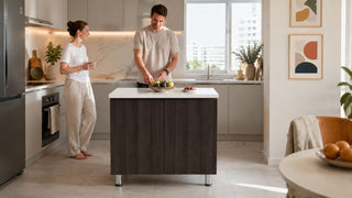 Dark wood kitchen island in a bright modern Singapore kitchen with a couple preparing fruit.