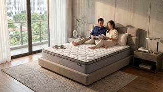 Couple relaxing on a large family mattress in a warm condo bedroom with city views and neutral decor