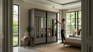 Man checking a large sliding-door wardrobe with mirrored panels in a spacious landed bedroom