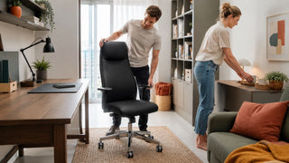 Black leather office chair in a bright modern Singapore home office with a couple arranging the workspace.