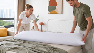 White long pillow arranged on a modern Singapore bedroom bed by a couple in a bright, practical home setting.