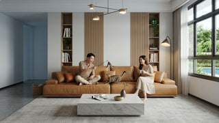 Couple playing with a cat on a low tan sofa in a bright modern living room