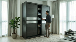 Man opening a dark sliding wardrobe in a modern Singapore bedroom with folded clothes, floor lamp, and soft neutral curtains