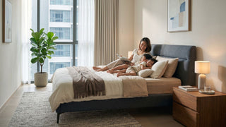 Mother reading with two children on a comfortable mattress in a Singapore condo bedroom