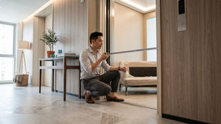 Man measuring lift entrance clearance for furniture delivery in a modern Singapore apartment corridor