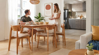 Light wood dining table with cushioned chairs in a bright Singapore home dining area set for a casual meal.