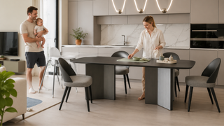 Parent holding baby near high chair while setting a modern dining table for family mealtimes