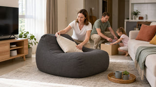 Charcoal bean bag chair in a bright Singapore HDB living room with a family arranging cushions before guests arrive.