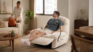 Cream recliner chair in a modern Singapore living room with a couple arranging cushions and relaxing at home