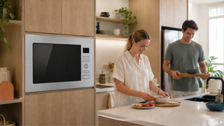 Built-in microwave in a modern Singapore kitchen with a couple preparing food in a warm, practical home setting.