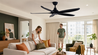 Modern black ceiling fan in a bright Singapore living room with family-friendly seating and warm home decor