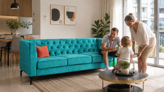 Turquoise Chesterfield sofa in a bright modern Singapore living room with a family preparing the space for guests
