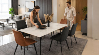 White marble-look dining table with mixed charcoal and brown chairs in a compact Singapore HDB dining layout
