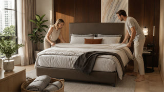 Couple arranging a duvet on an upholstered bed in a modern Singapore bedroom for practical bedding comfort