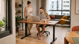 Electric standing desk in a modern Singapore home office with a couple setting up a practical work-from-home space.