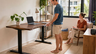 Electric standing desk in a bright Singapore home office with a couple setting up a practical work area.