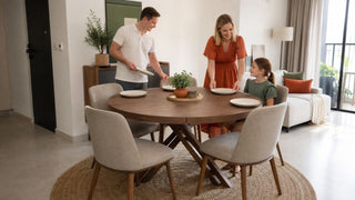 Expandable round dining table in a compact Singapore condo dining area with a family setting the table.