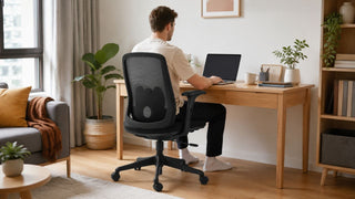 Black mesh office chair in a bright Singapore home office with a practical work-from-home desk setup.
