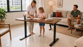 oung family using a manual standing desk as a shared work surface in a modern Singapore home.