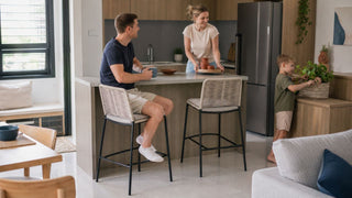 Cream woven high bar stools at a compact kitchen counter in a modern Singapore HDB home with a relaxed family moment.