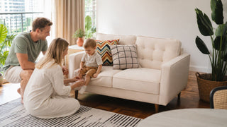 Cream kids sofa in a bright Singapore family living room with parents helping a child settle comfortably