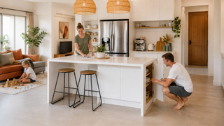 Family tidying a white kitchen island with wooden bar stools in a modern Singapore home, showing easy-clean surfaces and practical storage.