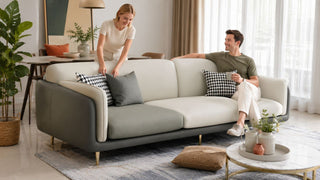 MegaFurniture leather sofa in a bright Singapore living room with a couple arranging cushions in a practical modern home.