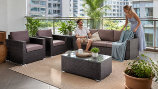 Outdoor sofa set on a modern Singapore condo balcony with a relaxed couple arranging the seating area