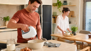 White hand mixer used for baking in a warm modern Singapore kitchen dining area by MegaFurniture.