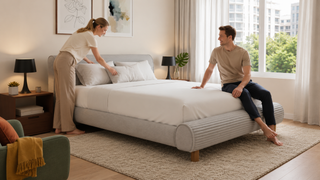 Modern modular bed frame in a bright Singapore bedroom with a couple arranging pillows in a practical home setting.
