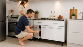 White modular kitchen cabinet with dark countertop in a modern Singapore HDB kitchen, with a couple checking storage layout before use.
