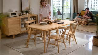 Oak dining table set in a bright modern Singapore home with a family preparing the dining area for everyday use.