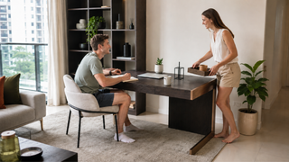 Modern office desk in a bright Singapore apartment home workspace with a couple arranging a practical work-from-home setup.