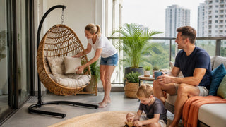 Outdoor swing chair with cushioned rattan seat in a modern Singapore condo balcony with a family relaxing nearby.