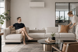 Cream modular sofa in a modern Singapore living room with a wall-mounted aircon above, styled for a practical family home.