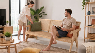 Rattan sofa in a bright Singapore living room with a relaxed couple styling cushions for a practical modern home.