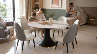Round marble-look dining table set used for homework in a compact Singapore family home with a nearby sleep area.