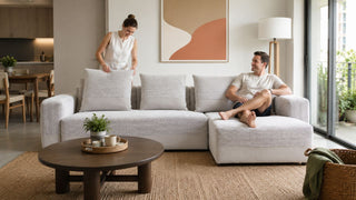 Light grey sectional sofa in a modern Singapore condo living room with a couple relaxing at home